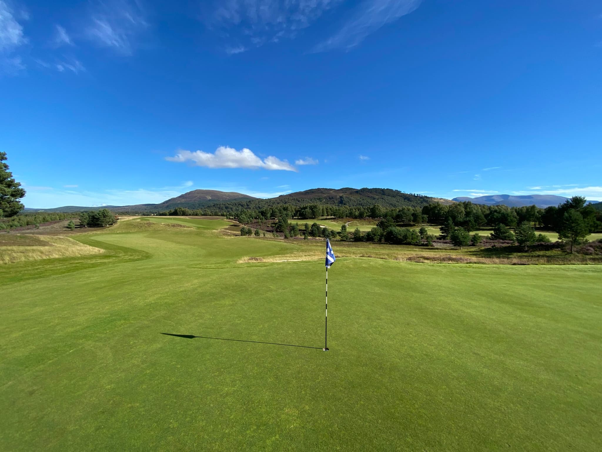 Firm fairways and flagstick representing the putting hole with blue skies