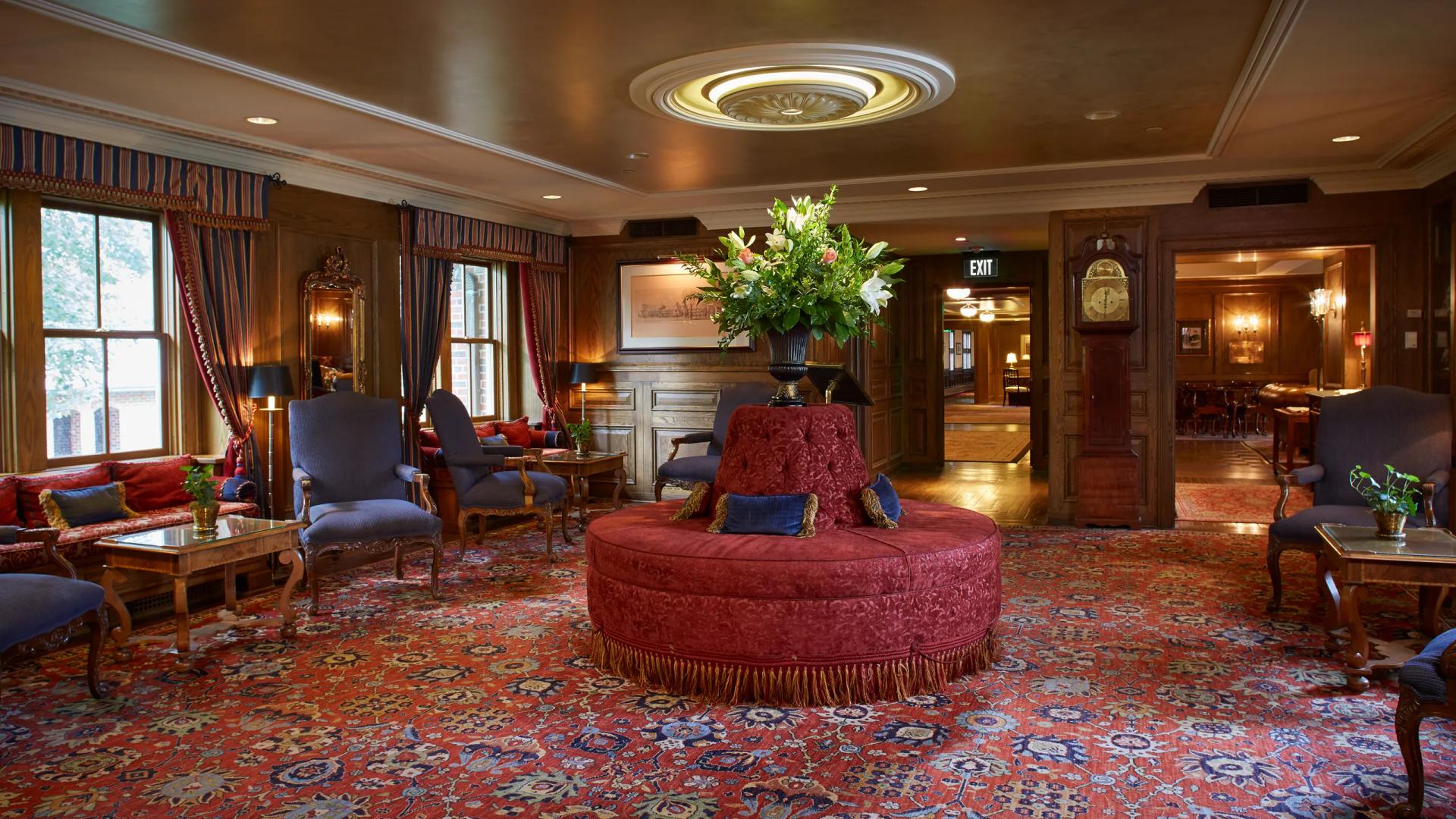 A cozy, vintage-style lounge with elegant furniture and floral arrangements.