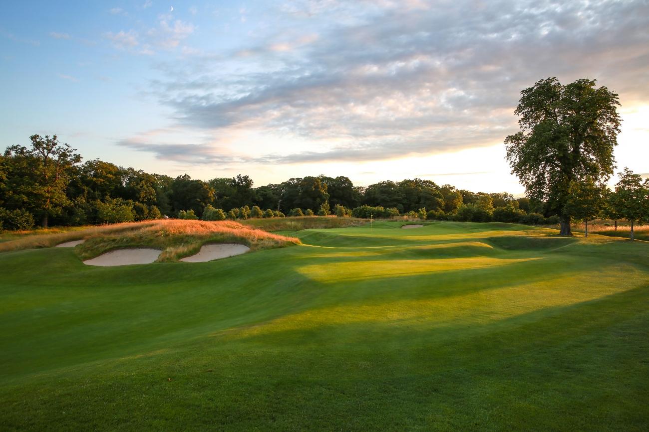 Sun setting over The Grove course nestled with trees causing shadows on the fairway and dunes