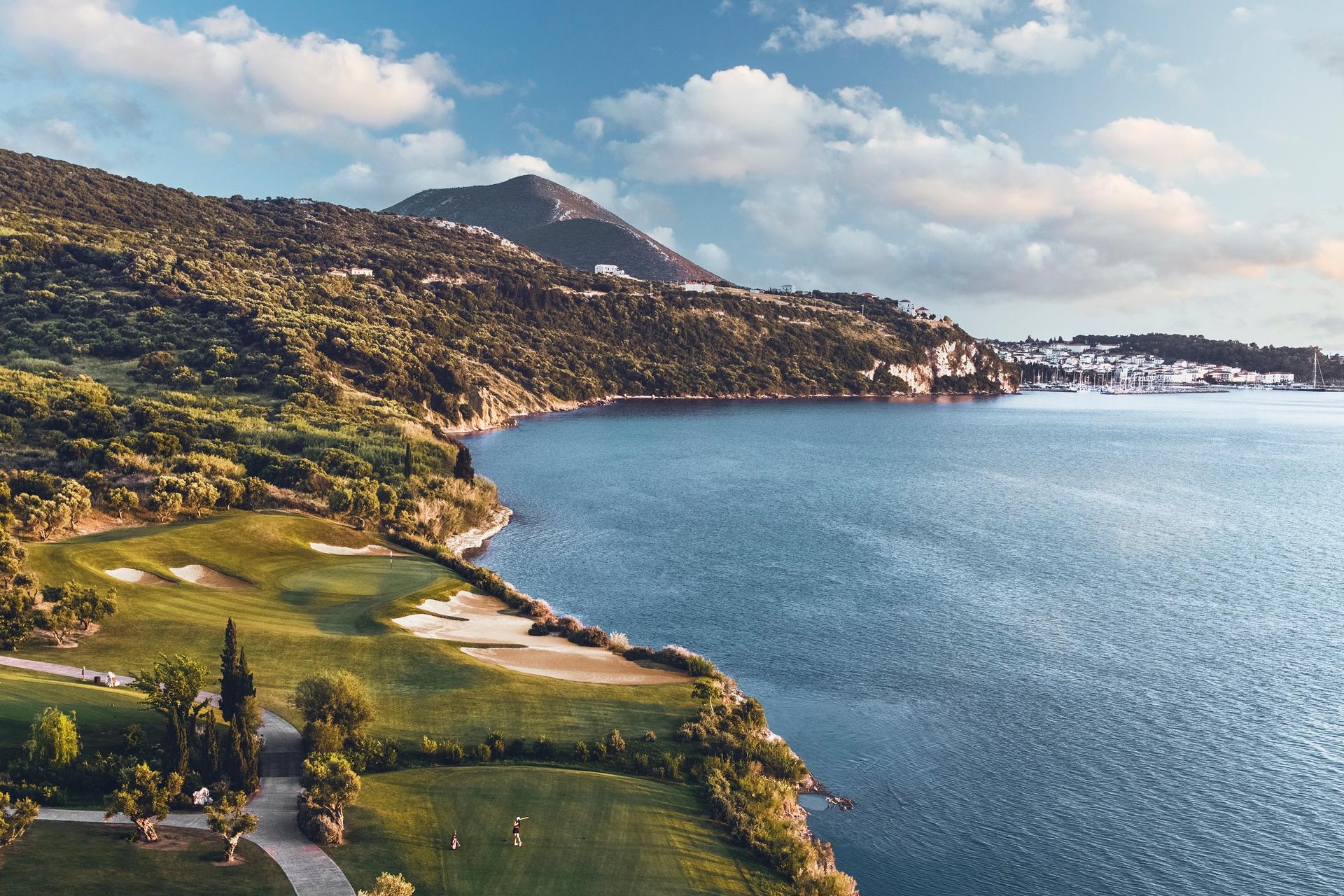 Golfer enjoying their round on a wide fairway that leads along the coast to a smooth green