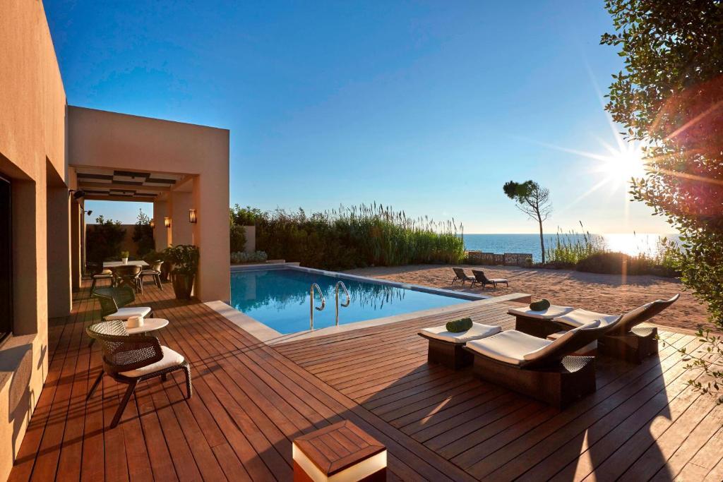 Sun setting over a villas personal swimming pool and private beach