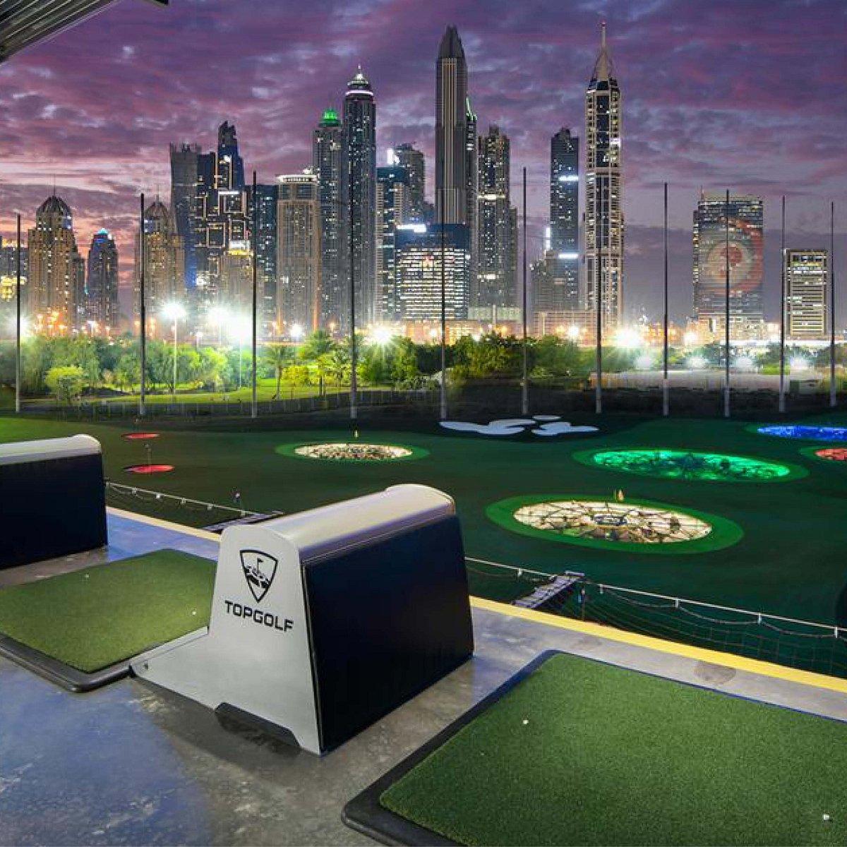 Golf tee box overlooking illuminated city skyline