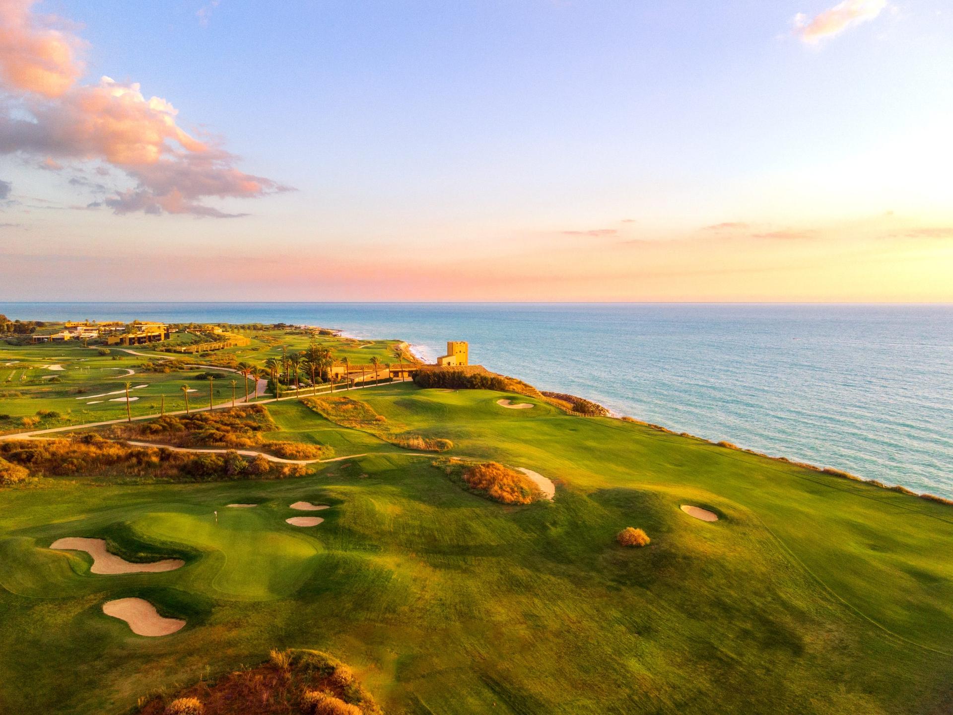 Sunset over the lush golf course with the ocean providing a stunning backdrop.