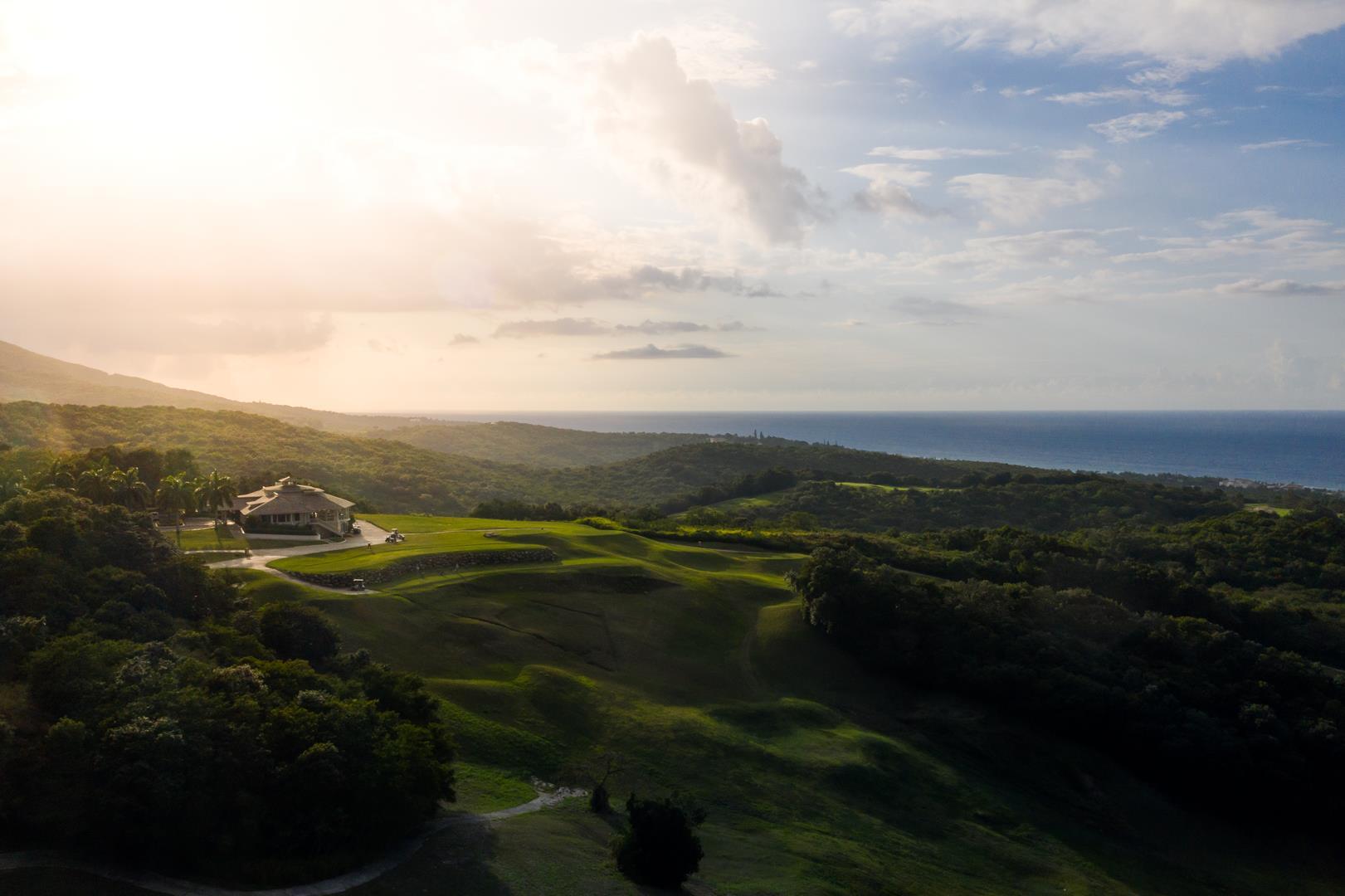 A dramatic landscape surrounds the clubhouse with rolling hills and coastal views.