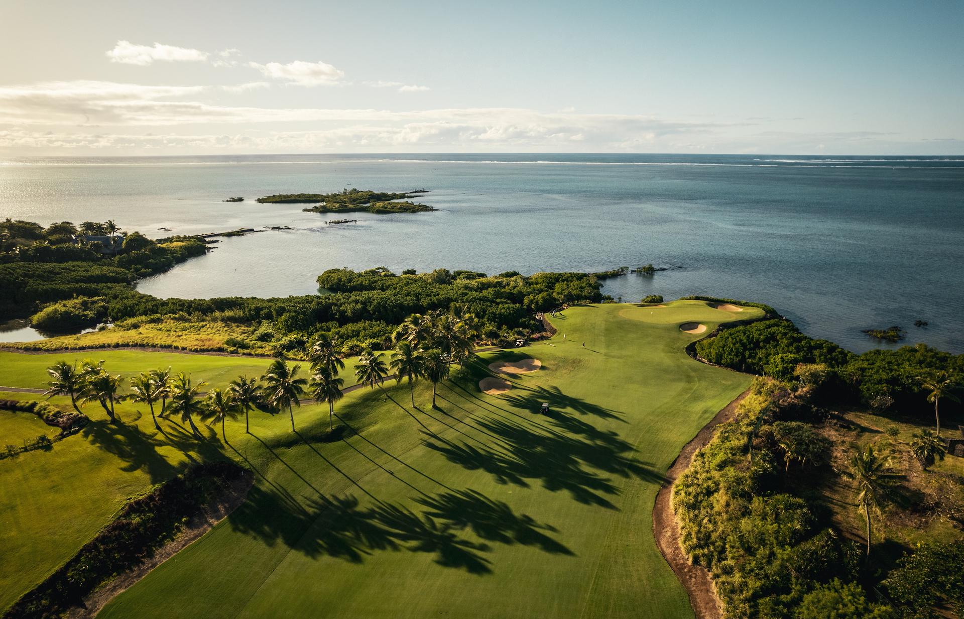 Aerial view of Els Course with a manicured fairway and green with the Indian Ocean behind