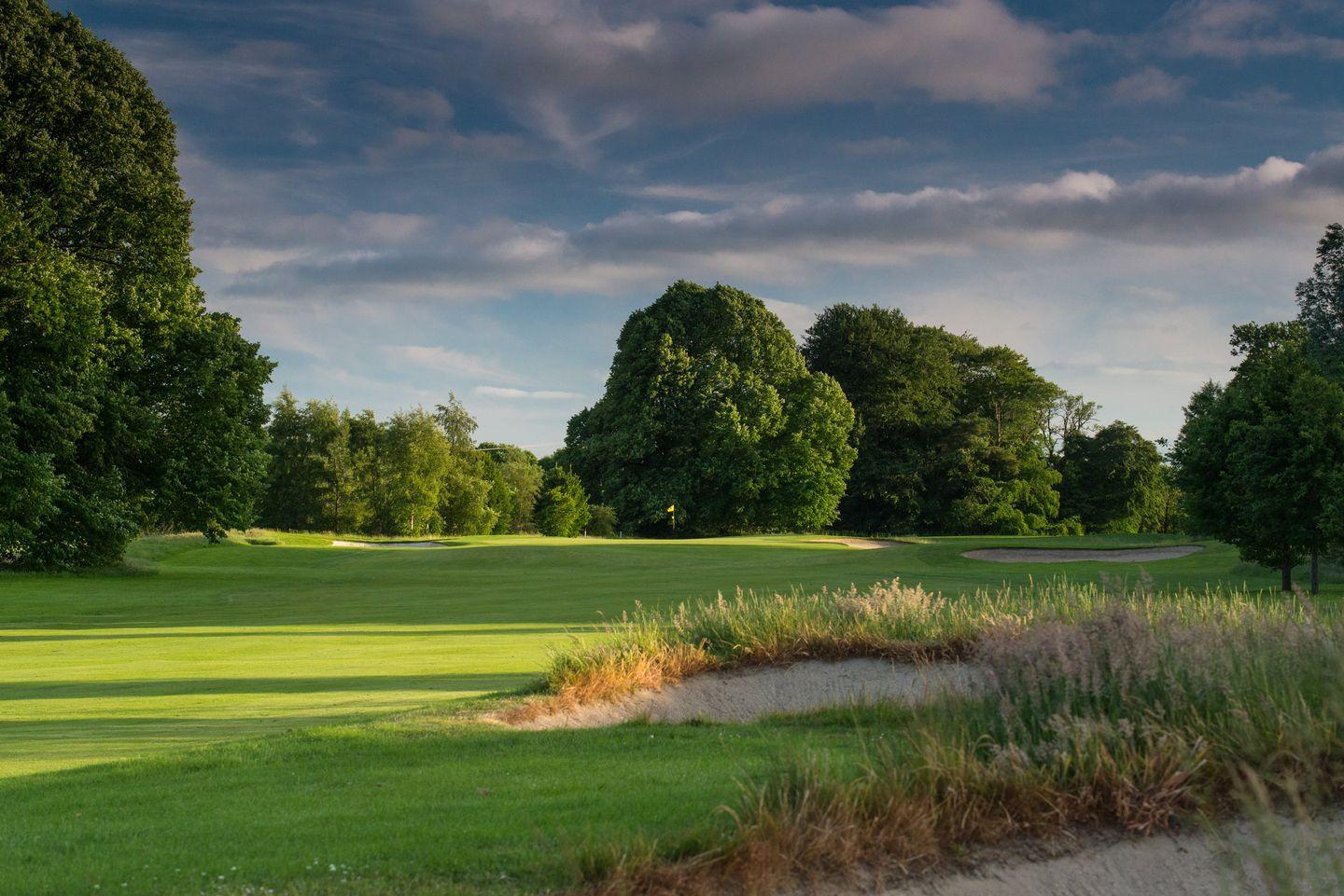 A wide fairway nestled with sand bunkers