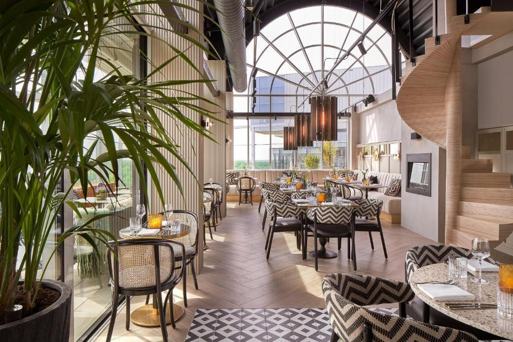 An modern dining room at the hotel with a grand spiral staircase and large panoramic windows