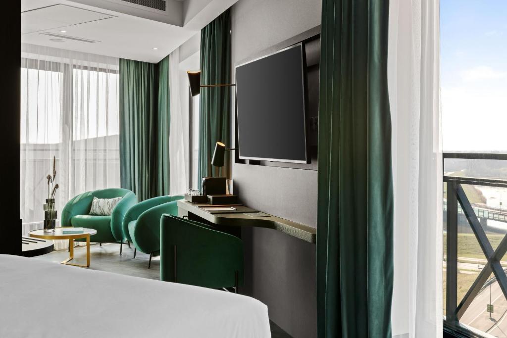 Lounging area and smart television alongside a balcony as part of a double bed suite