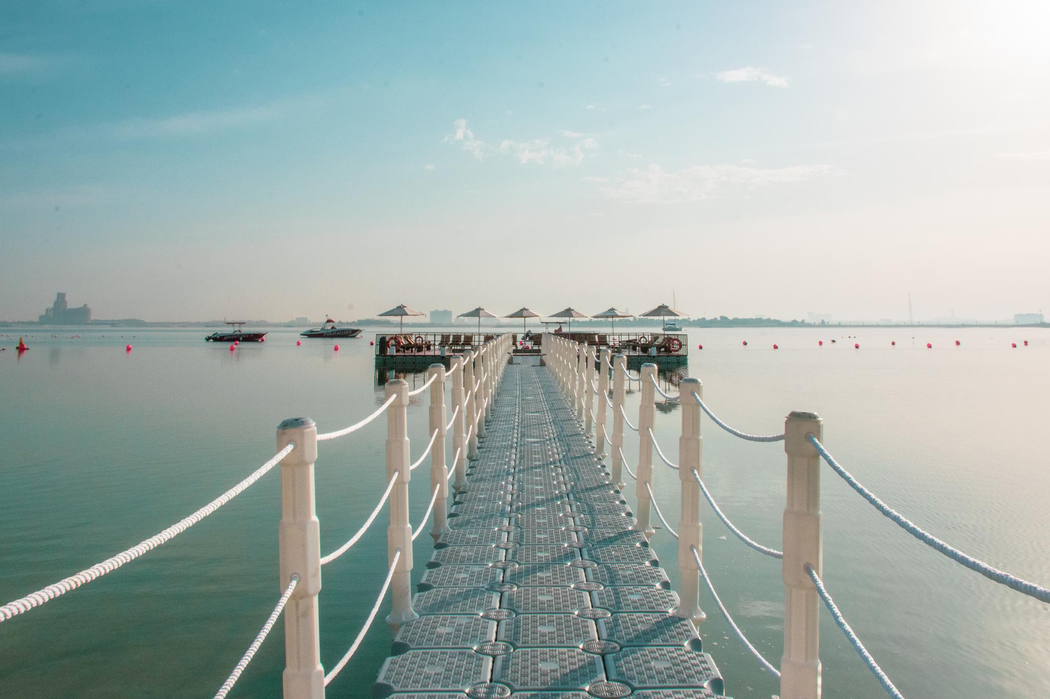 Pier overlooking the sea with sun beds at the end