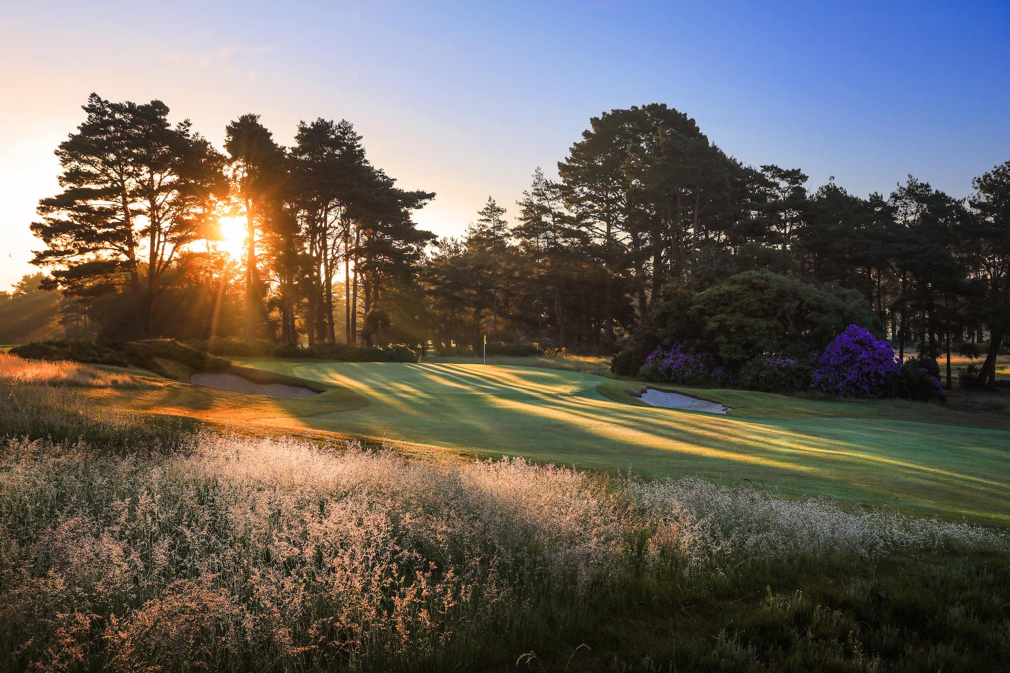 Sun setting over a smooth green at the course