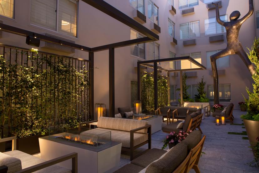 Outdoor seating area at the hotel with a statue that appears to be holding up something