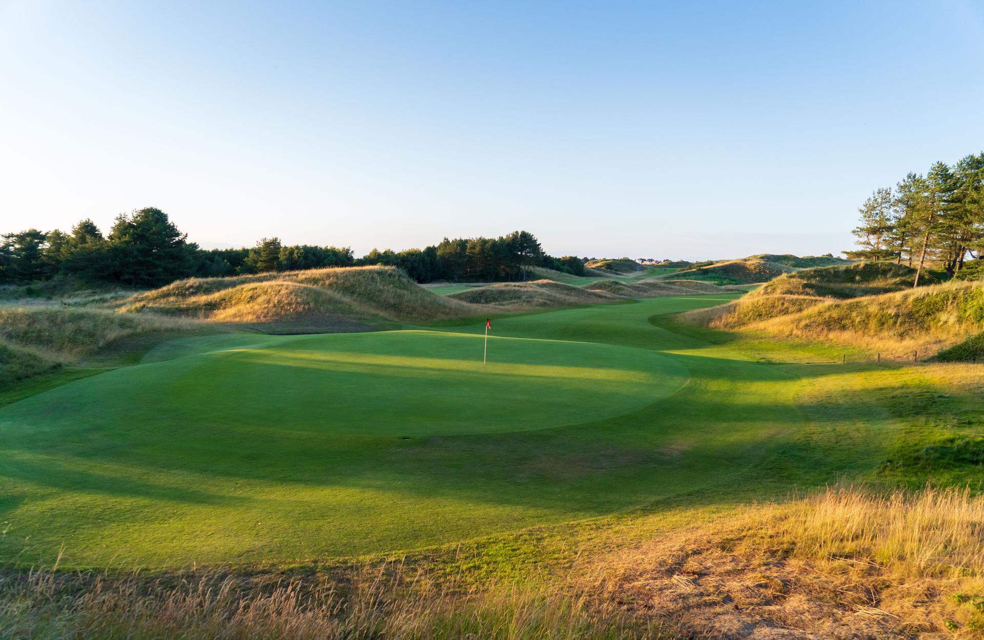 Panoramic view of a well maintained fairway leading a smooth green