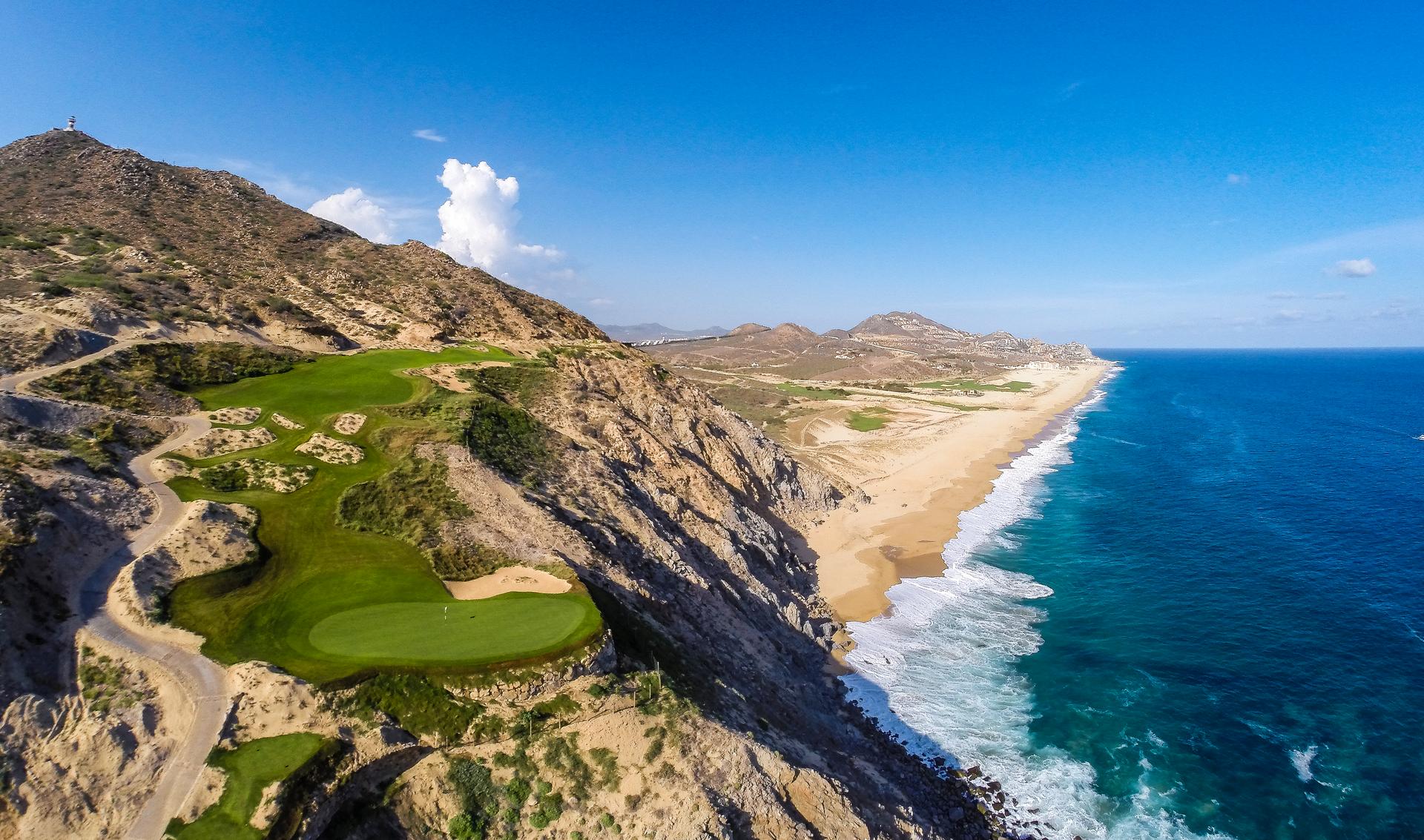 Overhead view of a coastal fairway leading to a smooth green off the side of a cliff