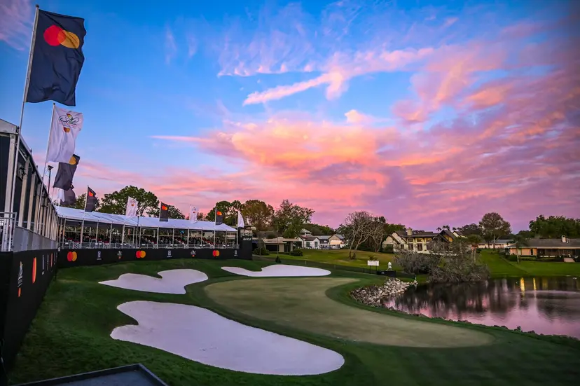 Spectator stands at the course overlooking a green surrounded by sand bunkers and a water hazard