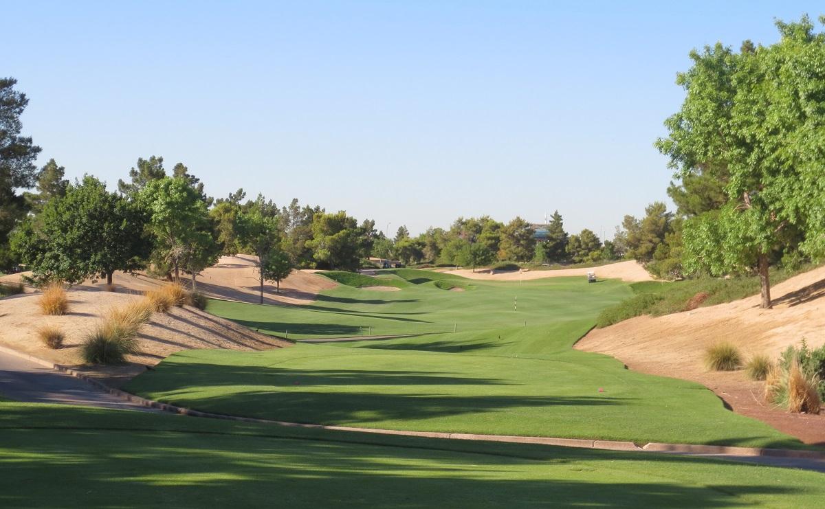A winding fairway nestled with deep sand bunkers leading to a well-kept green