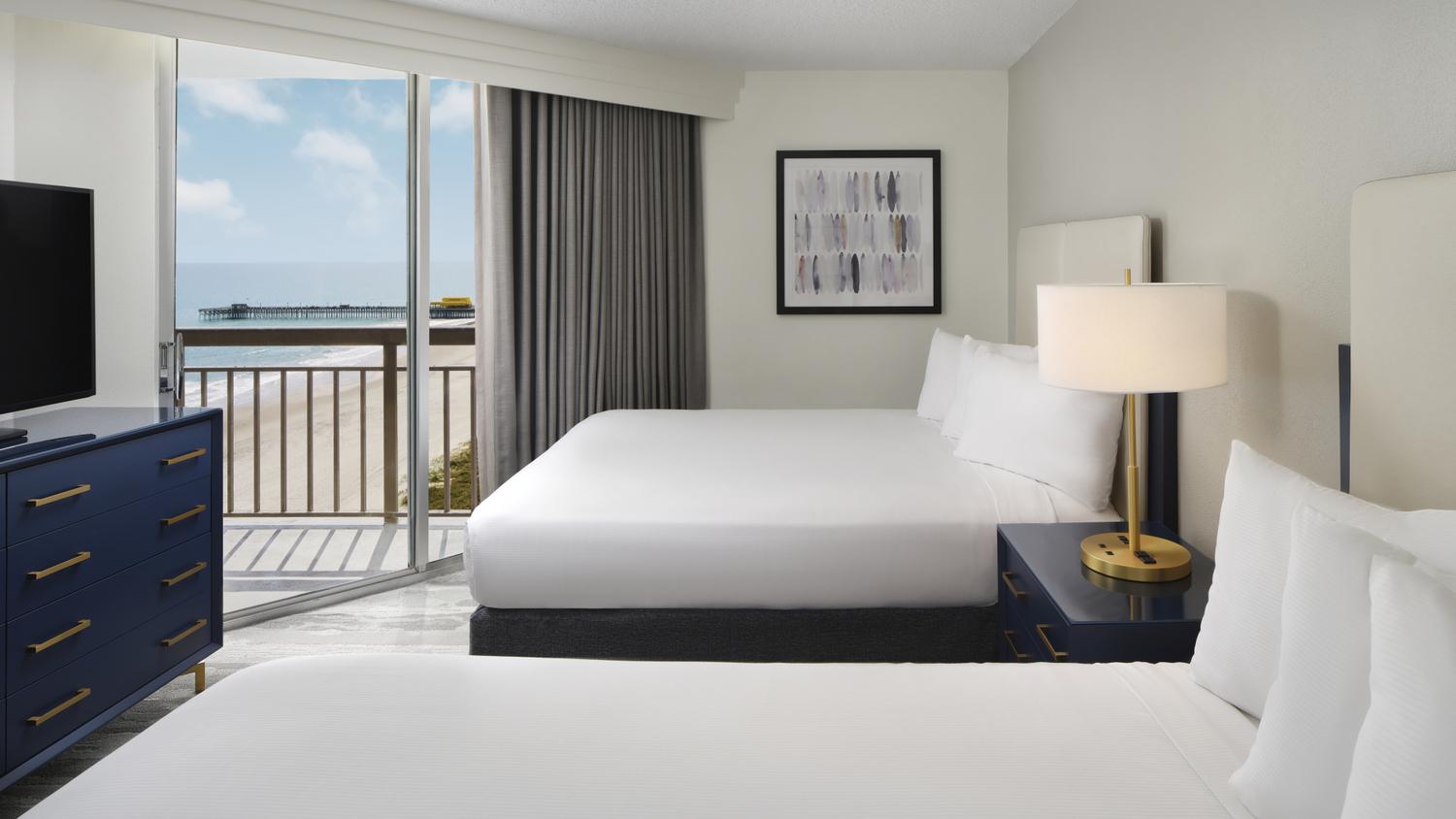 A modern twin double bed suite with balcony views