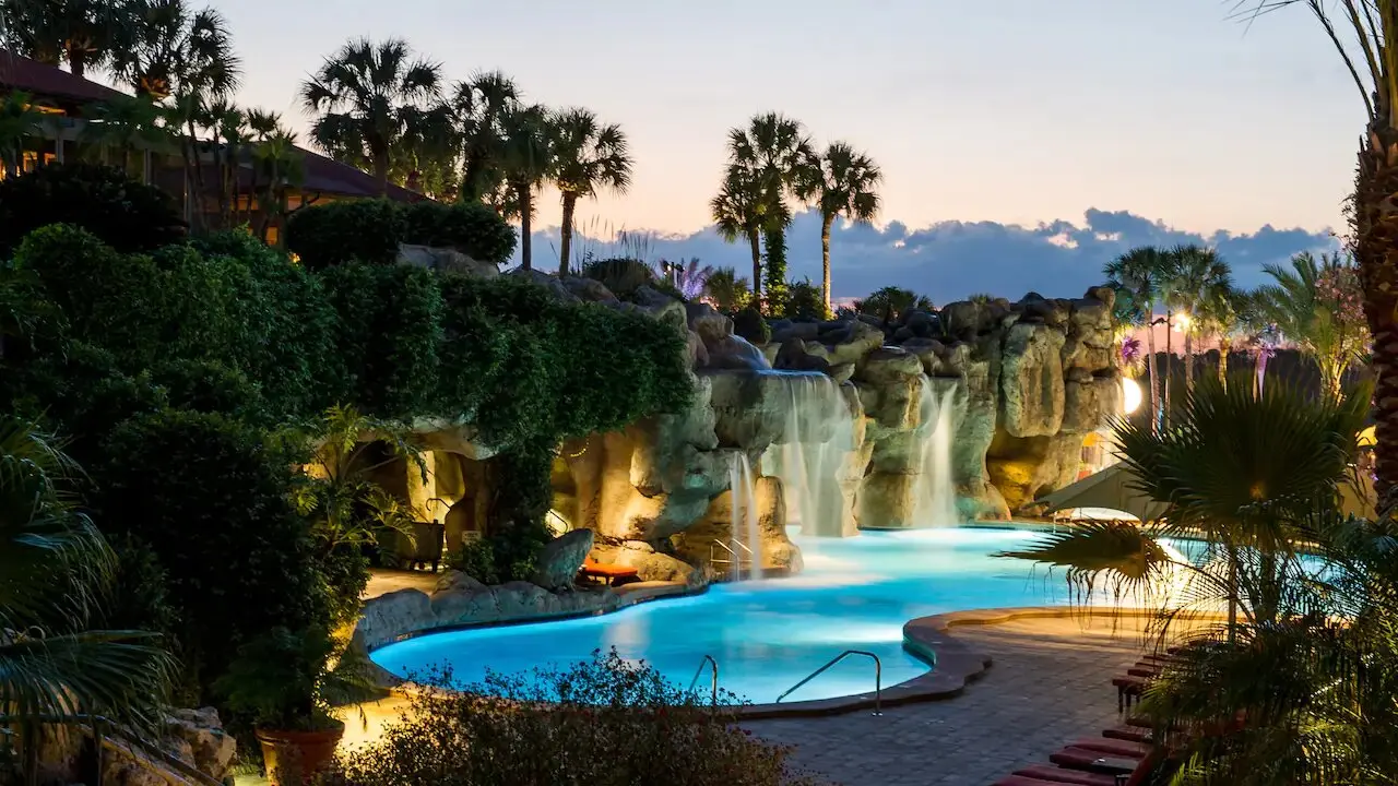 Outdoor swimming pool at the hotel with water fountain feature that leads through to a cave