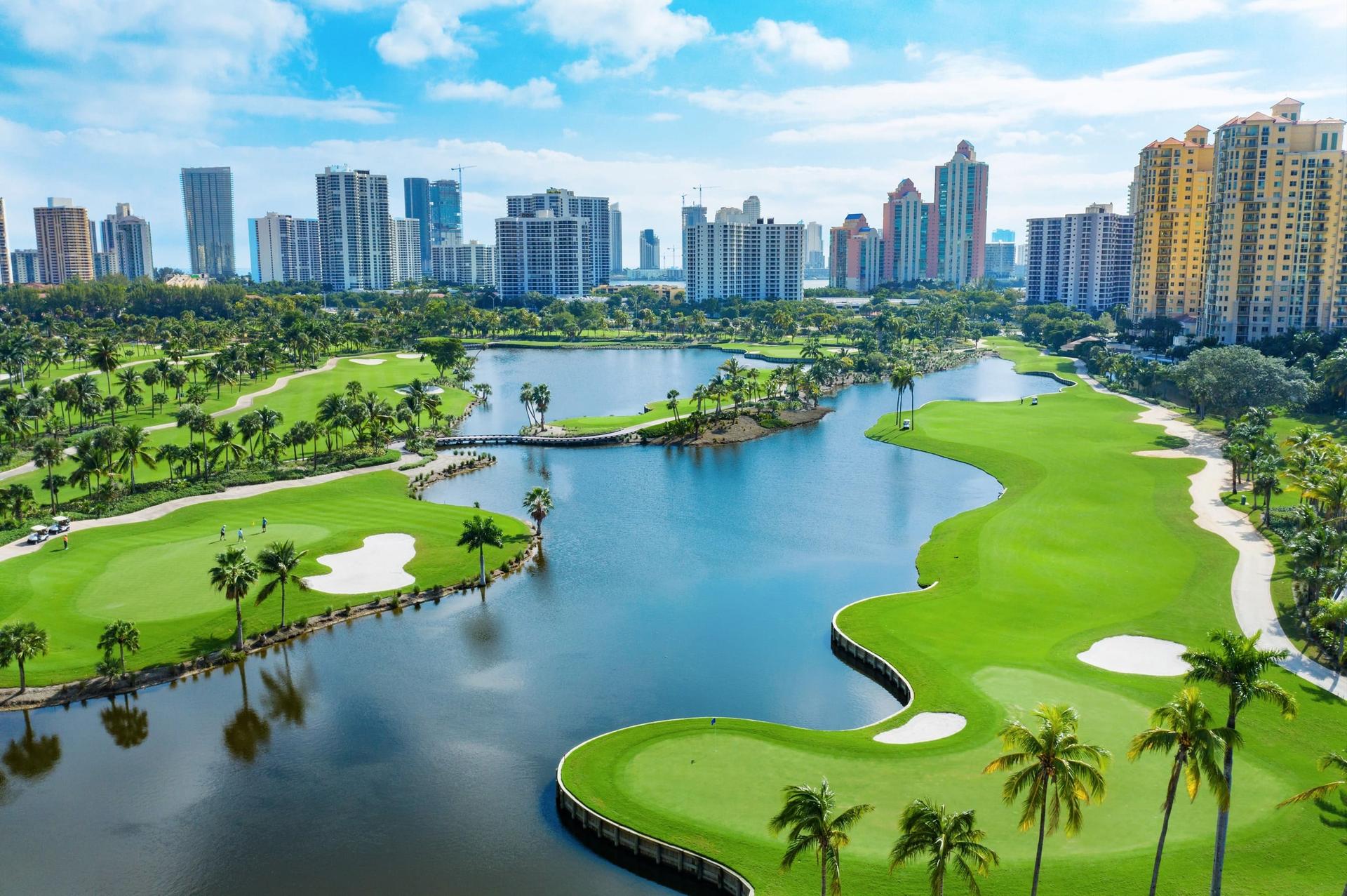 Birdseye view of a lake running through the JW Marriott Miami Turnberry's course with city views