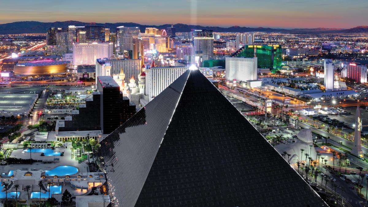 A luxurious all black pyramid with a light pointing to the sky from the tip