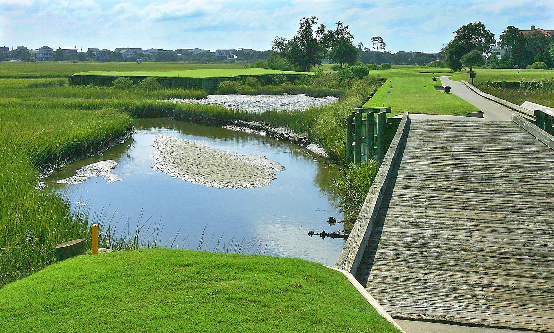 A wooden bridge to navigate the water hazard on the course
