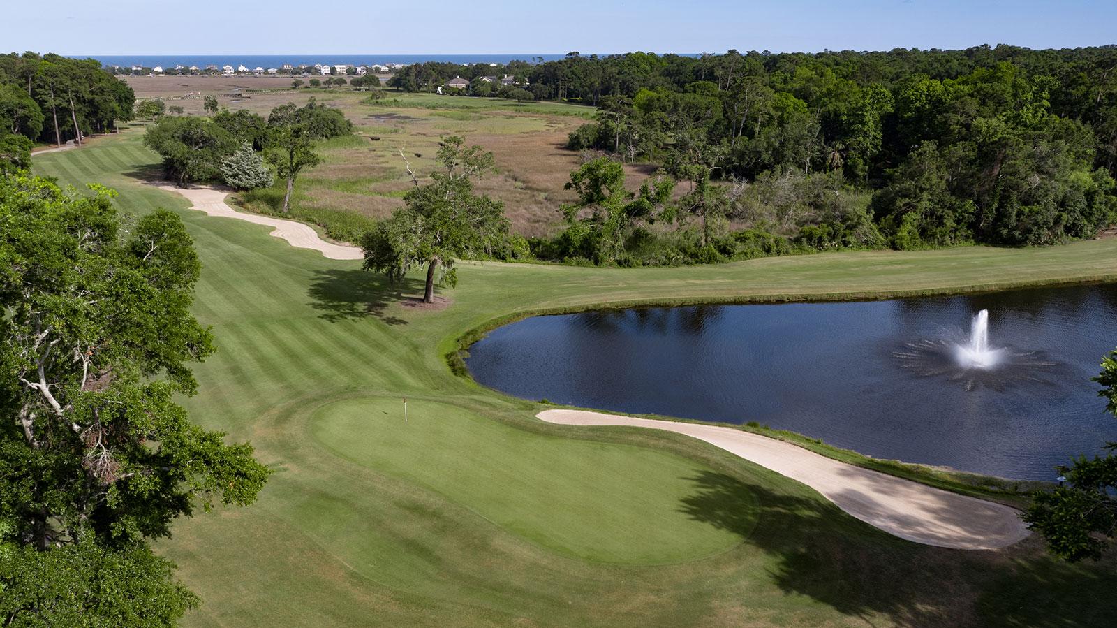 Overhead view of a winding fairway surrounding a water hazard