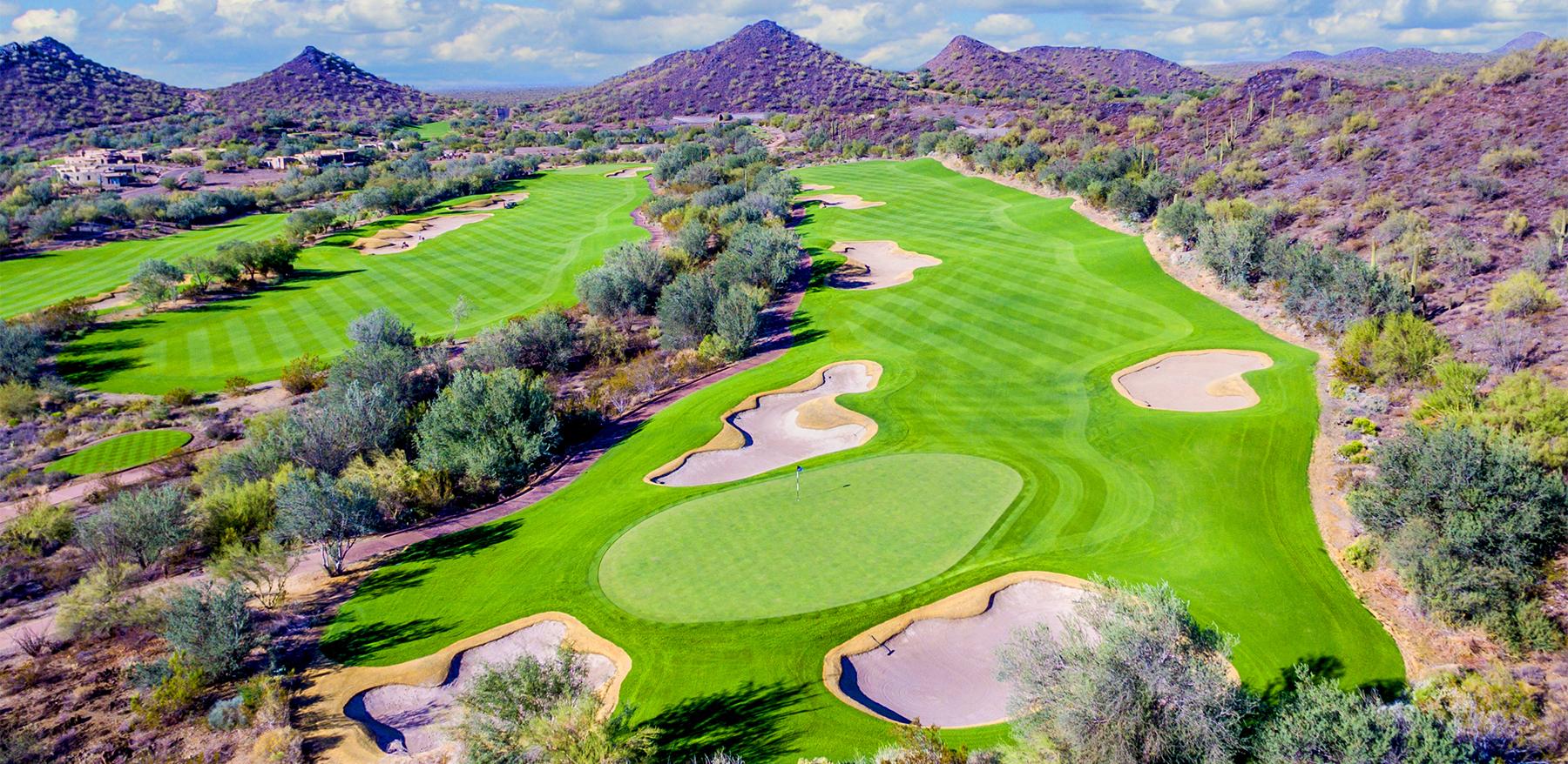 Overhead view of a well-maintained fairway leading to a smooth green surrounded by sand bunkers