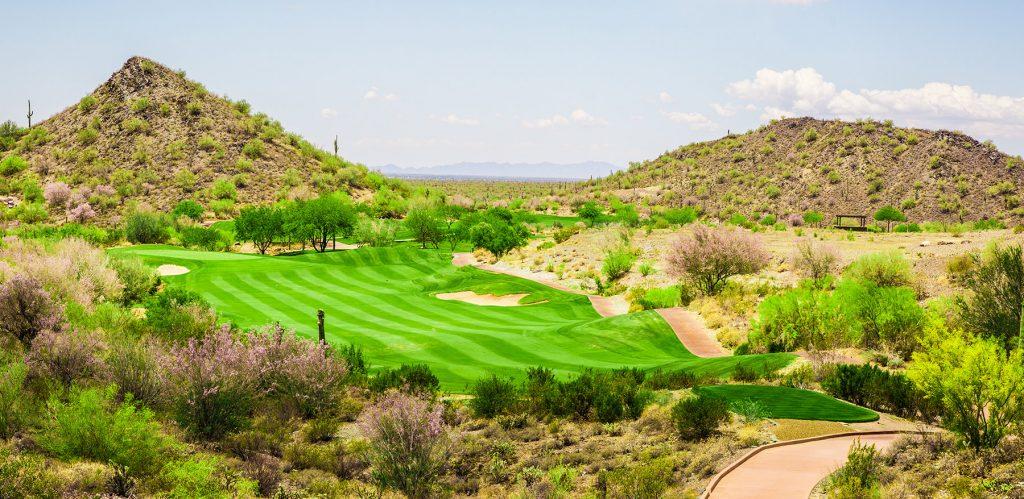 Rolling dunes and well-kept fairway surrounded by a mountainous rough