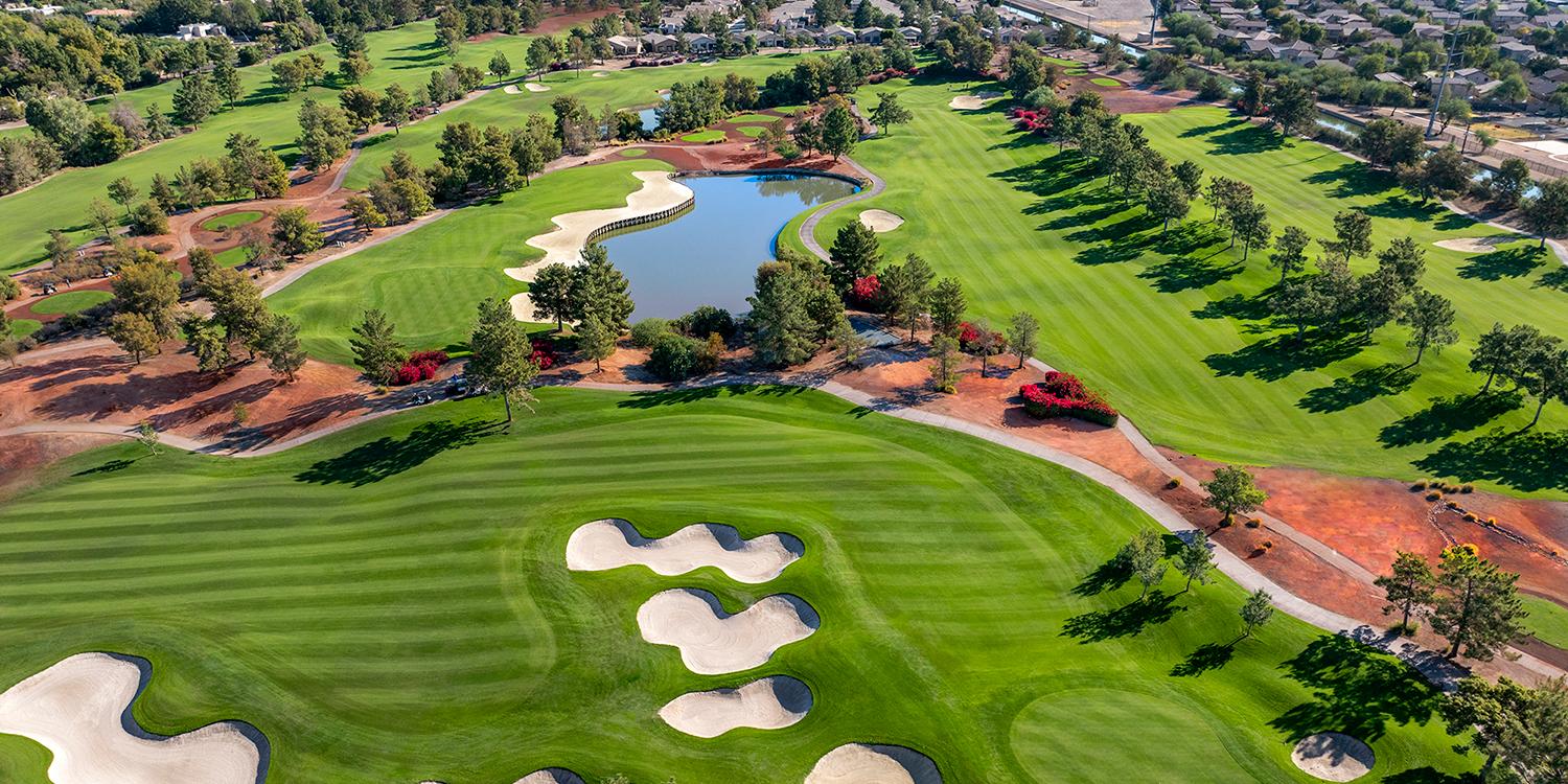 Overhead view of a winding fairway littered with sand bunkers