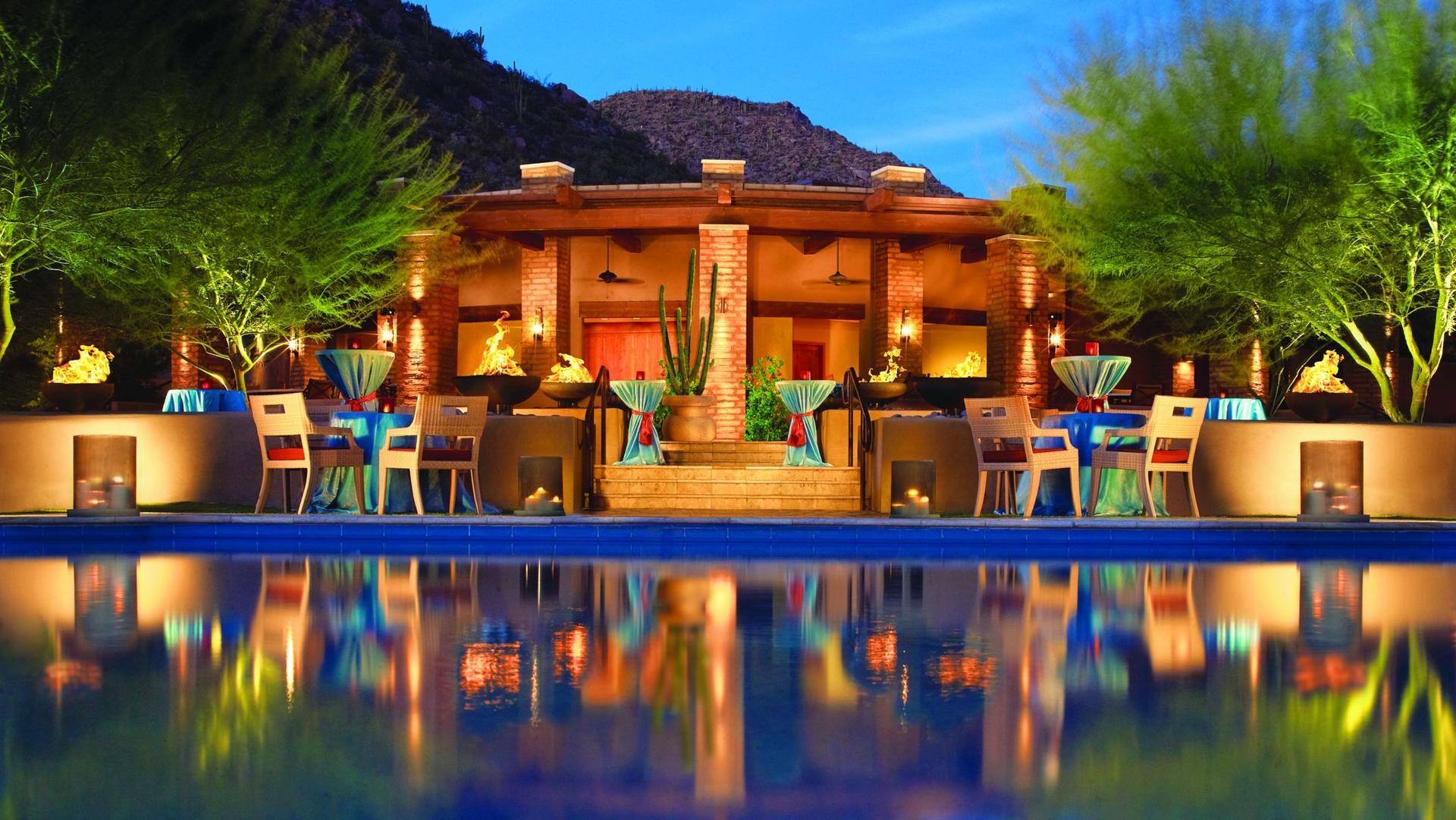 Exterior view of the resort building being lit up at night reflecting off the water