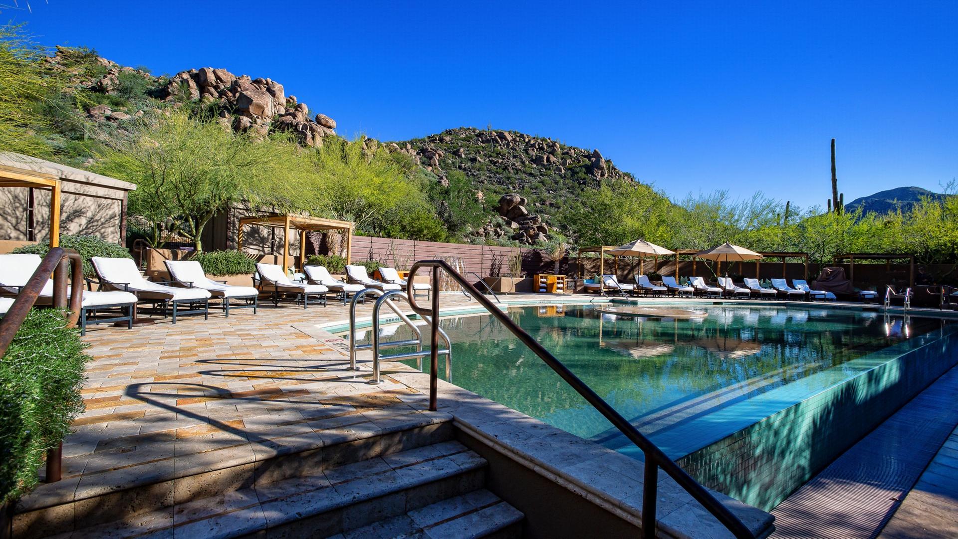 Outdoor swimming pool at the resort surrounded by sun beds