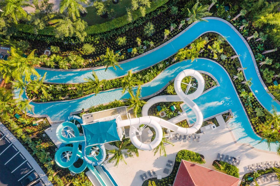 Winding water slide at the hotel surrounded by palm trees and other nature