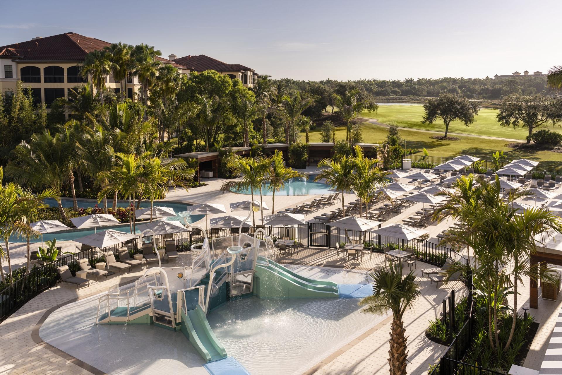 Overhead view of a kids pool, adult pool and multiple sunbeds at the resort