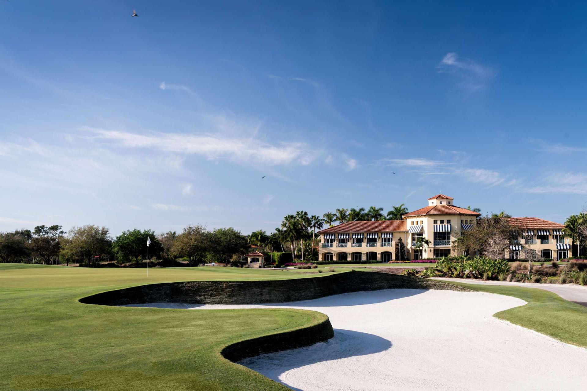 Large sand bunker places next to an elevated green just outside of the clubhouse