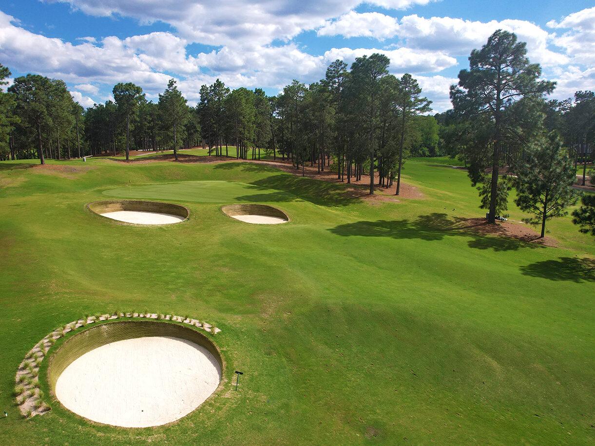 A wide fairway littered with sand bunkers
