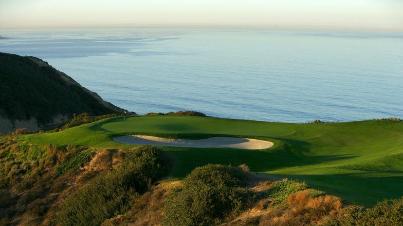 A smooth green at the Torrey Pines South Course placed next to a sand bunker with sea views