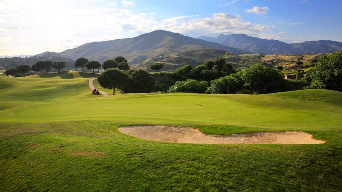 Green, greenside bunker and mountains in the background
