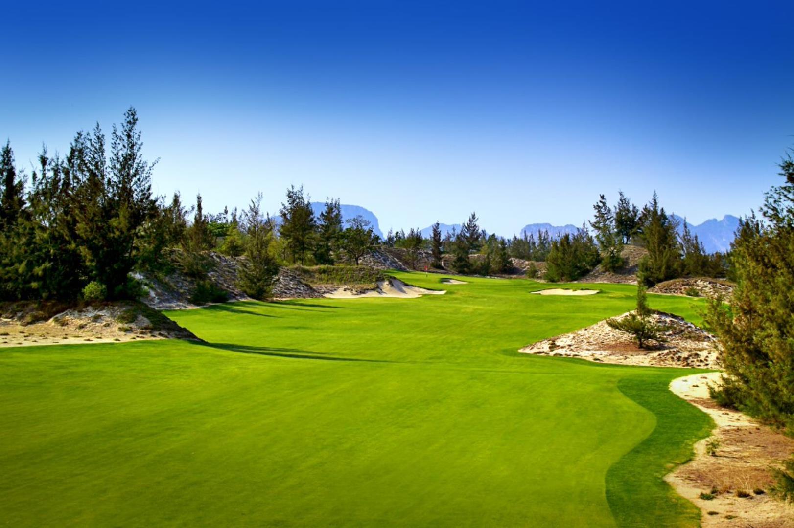 A well-maintained fairway leafing to a smooth green surrounded by sand bunkers
