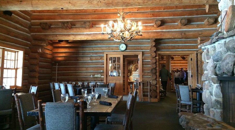 Rustic clubhouse dining area with log cabin design and cozy atmosphere.