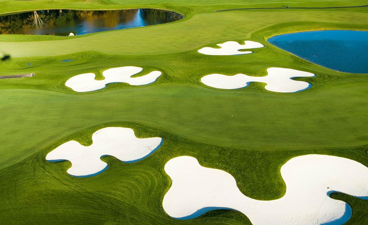 A winding fairway littered with uniquely shaped sand bunkers