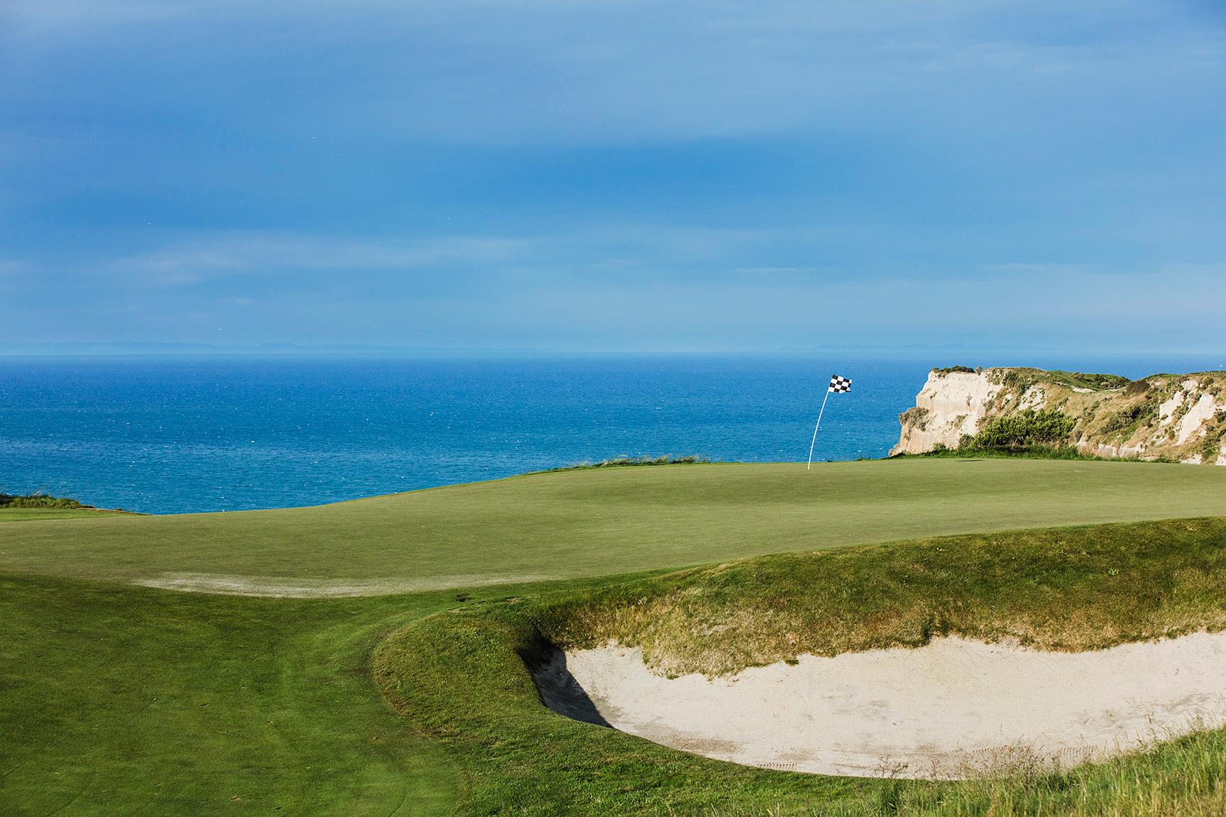 A smooth green sandwiched between the coast and a sand bunker