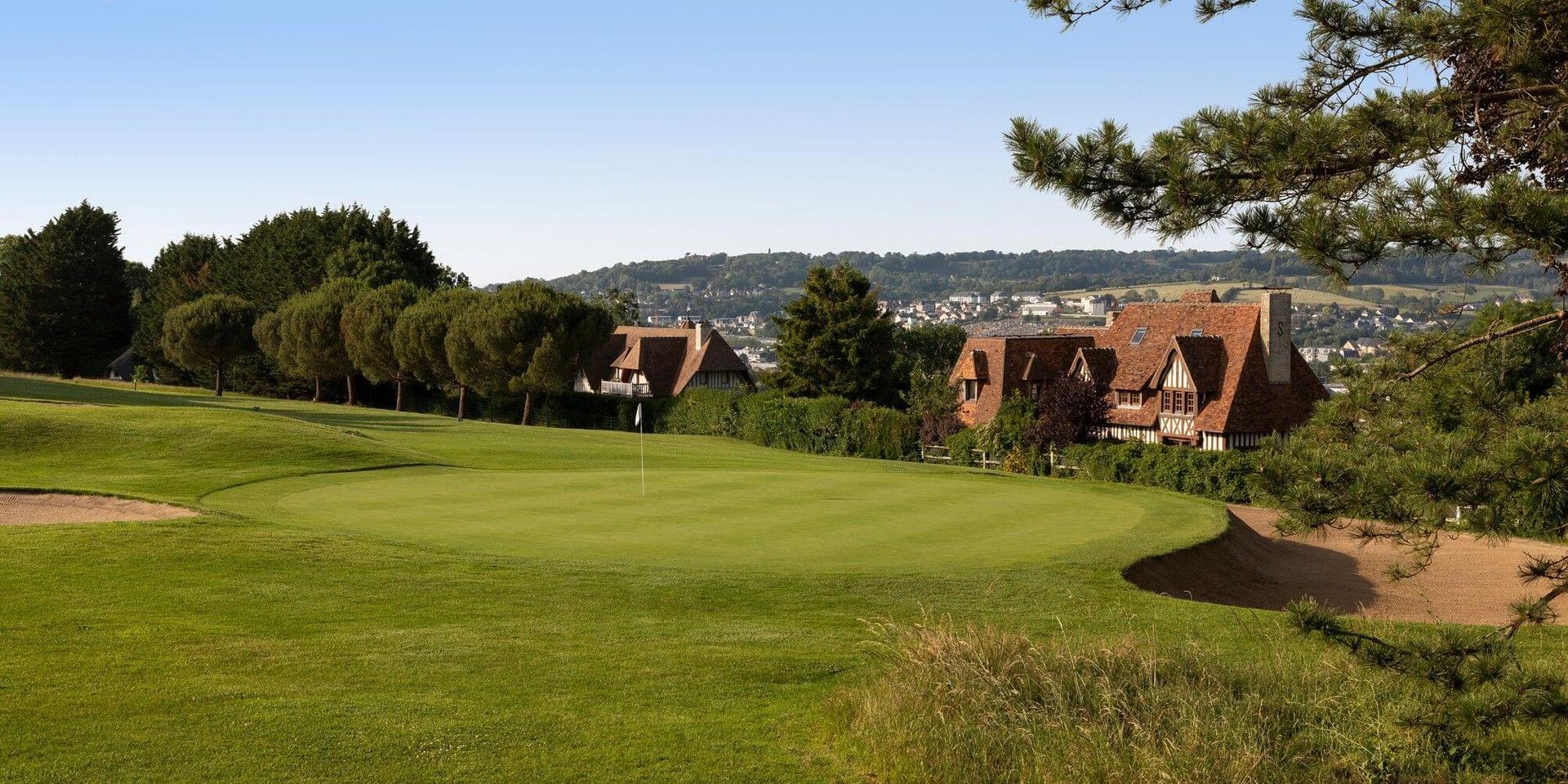 Manicured green with large bunker behind