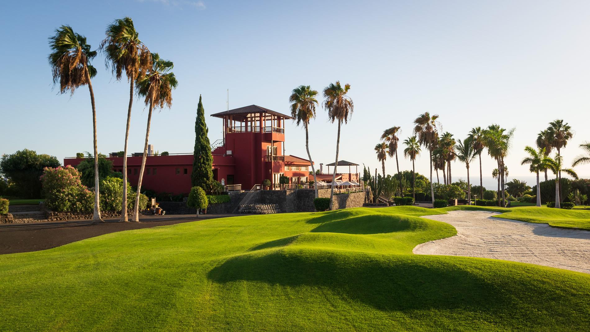 Iconic red clubhouse, manicured rough and palm trees