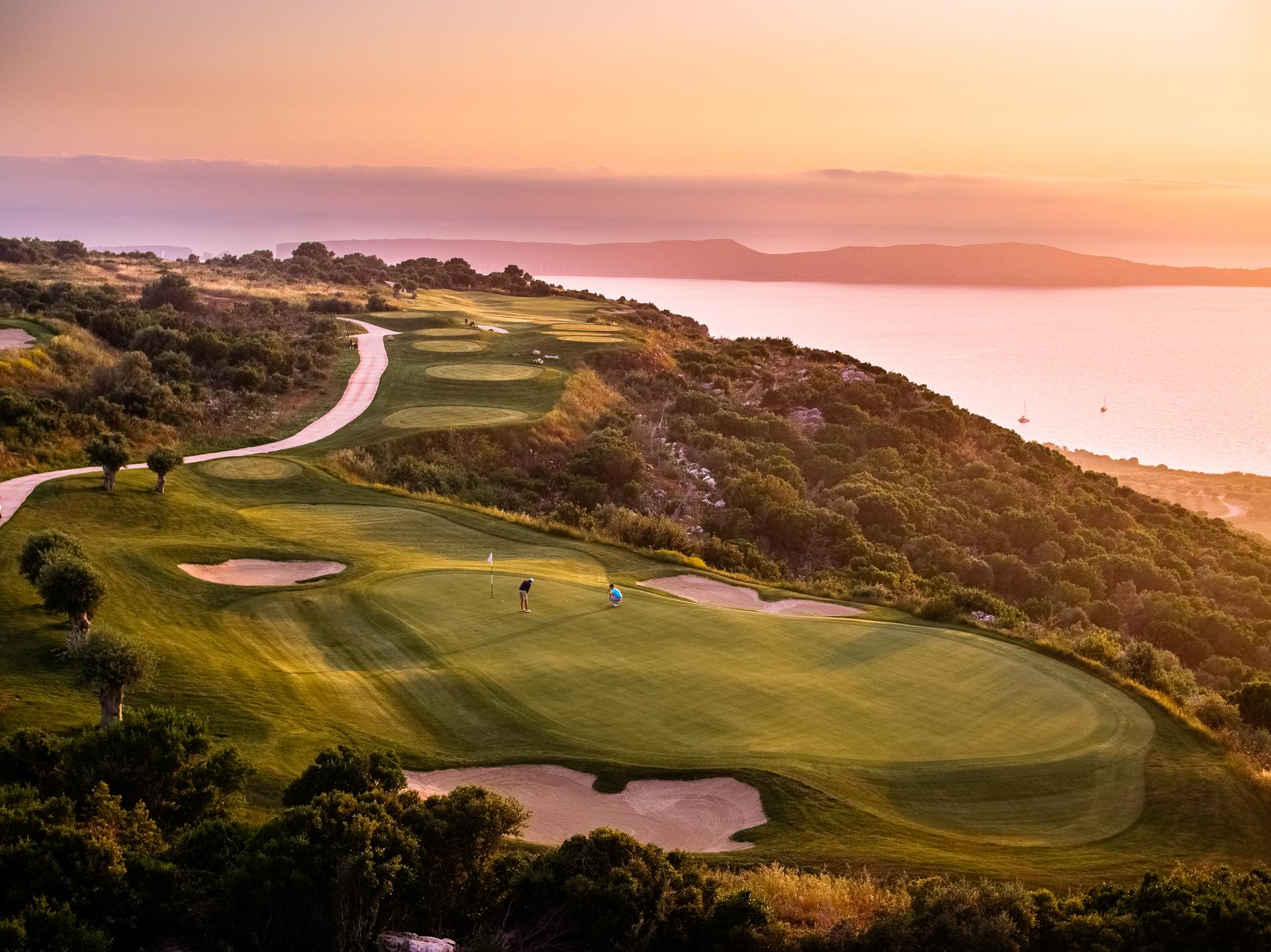 Overhead views of golfers putting on a manicured green with the sun setting over them