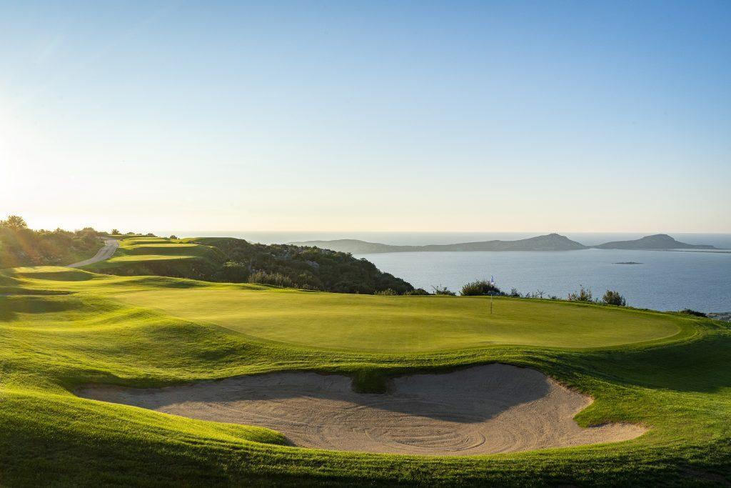 A smooth green and a strategically placed sand bunker with coastal views