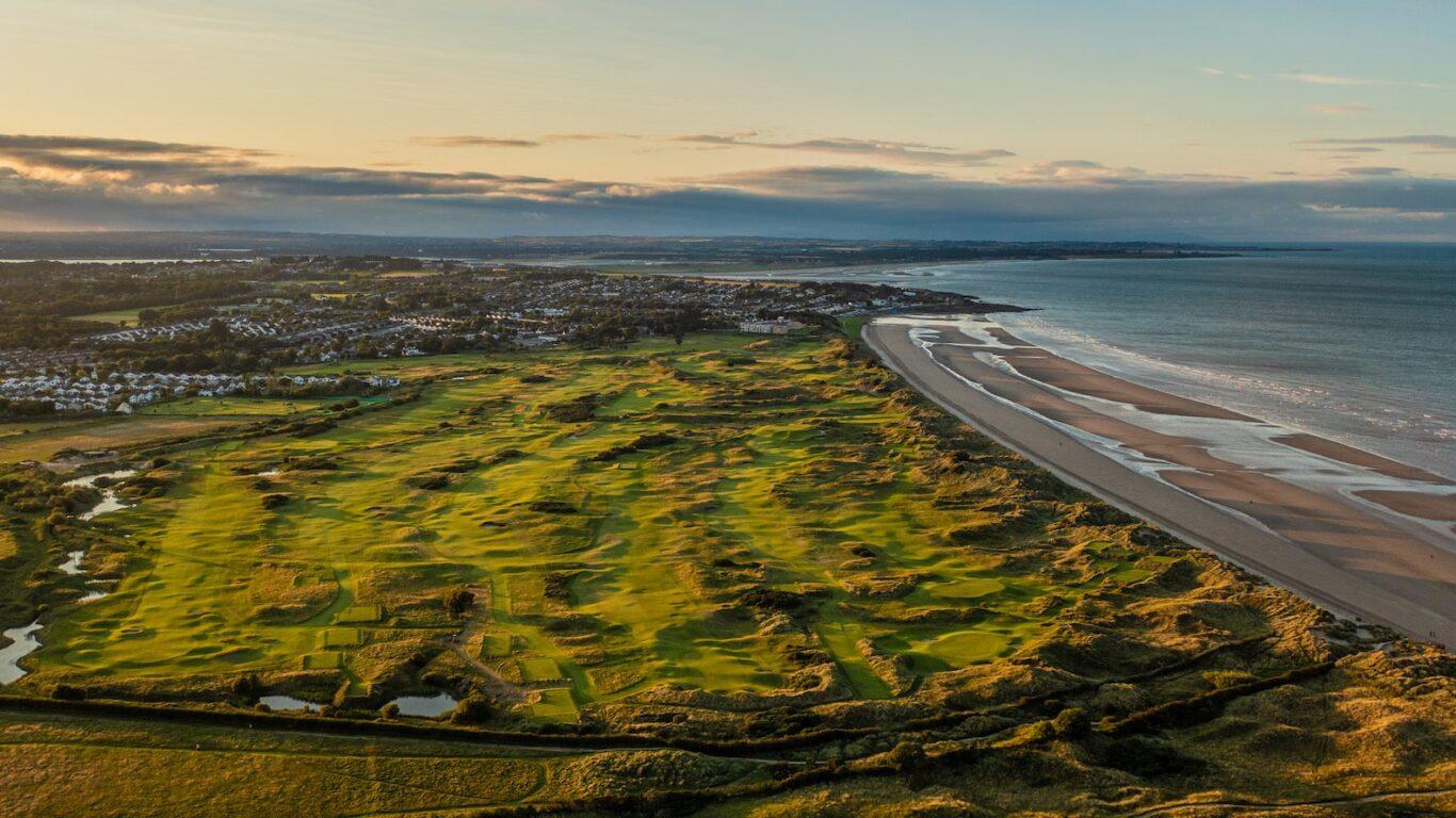 A wide panoramic view of the entire golf course stretching along the coastline.