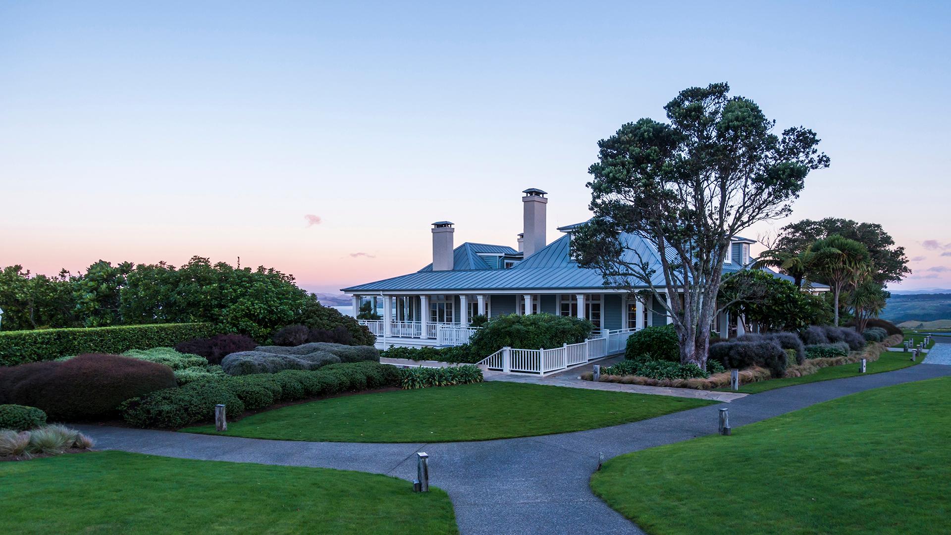 The Kauri Cliffs Resort clubhouse under clear evening skies