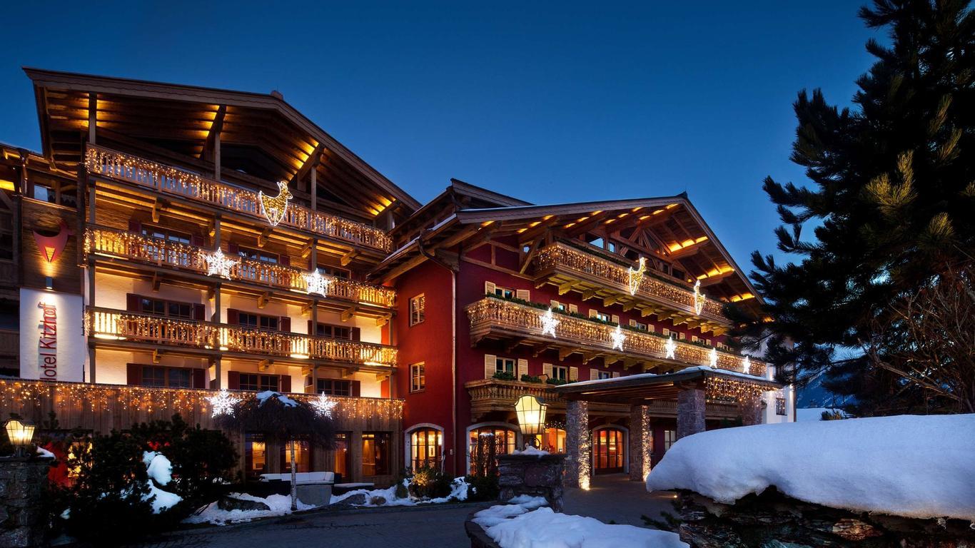 An exterior view of the front entrance to the Kitzhof Hotel with their logo scattered around the building