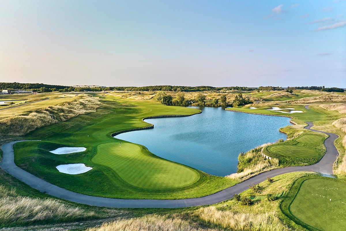Fairway winding around a water hazard to a sloping green