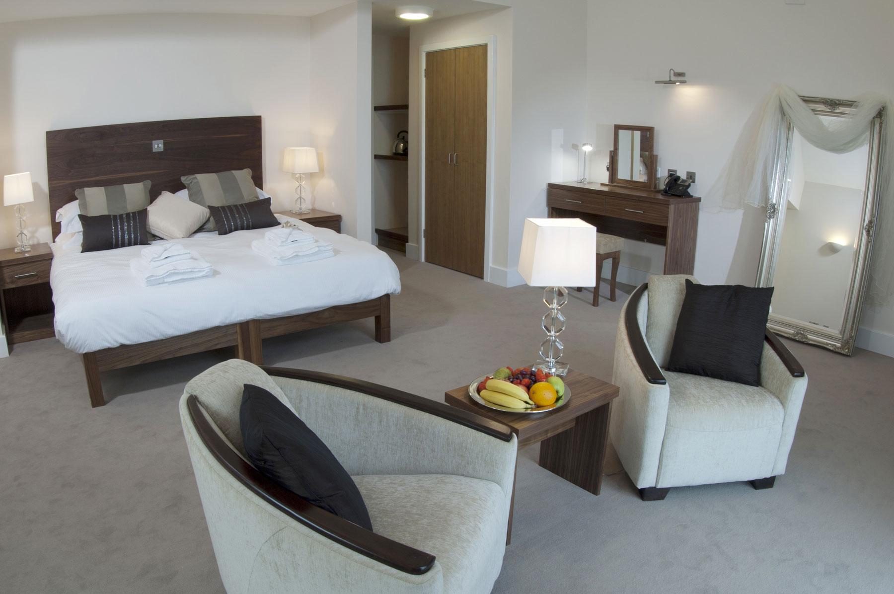Luxurious double bed suite in The Lodges by Prince's with seating area and complimentary fruit