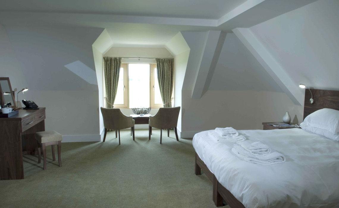 Modern double bedroom at The Lodges at Prince's with a seating area in front of the window to look out